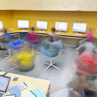 blurred photo of students spinning in chairs
